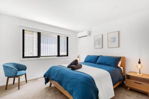 a bedroom with a bed with a teddy bear on it at Bellagio - Swimming Pool with Ocean Views in Callala Beach +27 photos