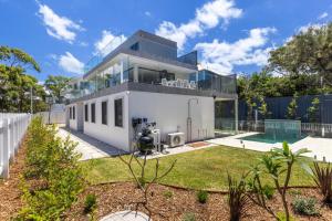 a large white house with a swimming pool at Bellagio - Swimming Pool with Ocean Views in Callala Beach