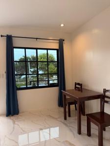 a room with a window with a table and a chair at Sea La Vie Guesthouse in Pooc