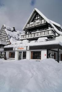 a building covered in snow with a pile of snow at Pension & Ferienhaus Latröpchen in Schmallenberg