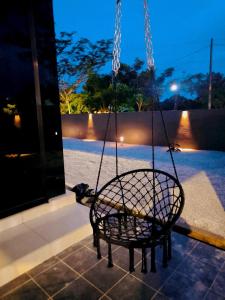 Eine Korbschaukel, die nachts an einer Veranda hängt in der Unterkunft Kulim Modern Bungalow in Kulim