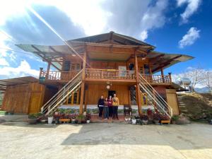 un gruppo di tre persone che si trovano di fronte a una casa di Sen Sapa Retreat & Tours a Sa Pa