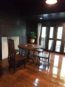 a dining room with a table and chairs and a potted plant at Montana Home in Ban Pok Nai