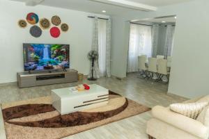 a living room with a tv and a couch at Grato Pacho in Kisumu