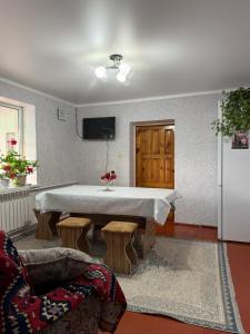 een woonkamer met een tafel en een koelkast bij Nurdan Guest House in Kara-Koo