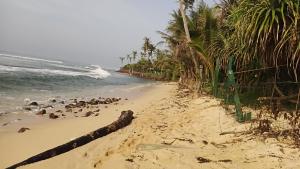 a beach with a bunch of rocks and the ocean at Luxury Living Villas in Matara