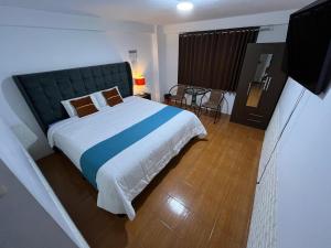 a bedroom with a large bed and a table at Cusco de mis Sueños in Cusco