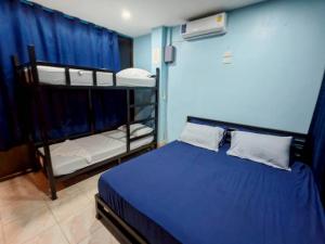 una camera con due letti a castello e una parete blu di Dee-maak Hostel a Thong Sala