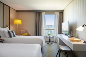 une chambre d'hôtel avec deux lits, un bureau et une fenêtre dans l'établissement Renaissance Paris La Defense Hotel, à Puteaux 87 autres photos