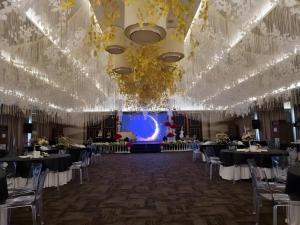 einen Bankettsaal mit Tischen, Stühlen und einer Bühne in der Unterkunft District 21 Hotel in Iloilo City