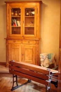 a cabinet with a teddy bear sitting next to a bench at Maison de la Fraternité in Ribeauvillé +10 photos