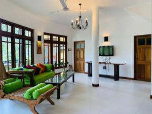 een woonkamer met een groene bank en een tafel bij Villa Rosa in Kandy
