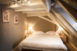 Un dormitorio con una cama blanca con dos lámparas. en Maison de la Fraternité, en Ribeauvillé
