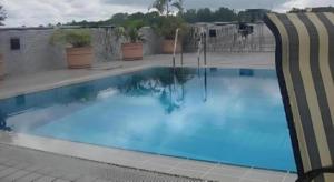 een groot zwembad met blauw water bij The CentrePoint Hotel in Kampong Kiulap