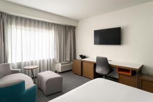 a hotel room with a bed and a desk at Courtyard Brunswick in Brunswick