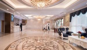 惠州Guangna Hotel的一间带吊灯和大厅的大房间