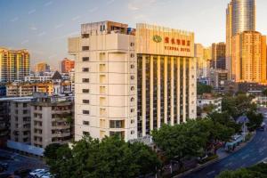 惠州Guangna Hotel的一座高大的建筑,上面有酒店标志
