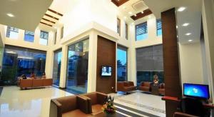 eine Lobby mit Stühlen und einem TV in einem Gebäude in der Unterkunft The Color Hotel in Hat Yai