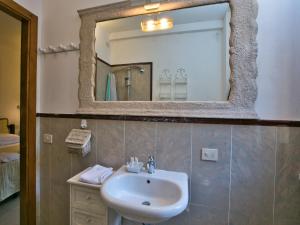 een badkamer met een wastafel en een spiegel bij Huge Holiday Home in Marina di Castagneto Carducci near Sea in Donoratico +33 foto's