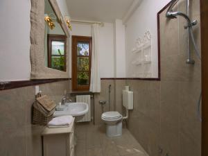 een badkamer met een toilet, een wastafel en een spiegel bij Huge Holiday Home in Marina di Castagneto Carducci near Sea in Donoratico