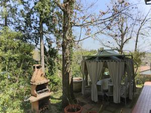 een tuinhuisje en een boom in een tuin bij Huge Holiday Home in Marina di Castagneto Carducci near Sea in Donoratico