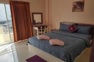 een slaapkamer met een bed met twee kussens erop bij V-House Hotel in Trang