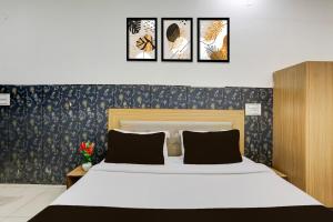 een slaapkamer met een bed met vier foto's aan de muur bij Hotel O Lohgarh Road Zirakpur Formerly JB Plaza in Zirakpur +22 foto's