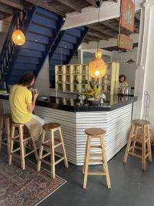 een man die aan een bar zit met twee krukken bij 90 Hostel in Ban Nua