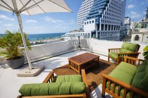 特拉维夫贝尔Spa精品酒店的阳台配有桌椅和雨伞。