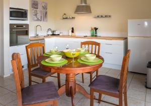 a kitchen with a wooden table with chairs and a dining room at Cottesloe Sea Bliss Apartment in Perth