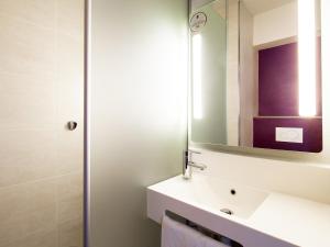 uma casa de banho com um lavatório e um espelho em B&B HOTEL Paris Romainville Noisy-le-Sec em Romainville