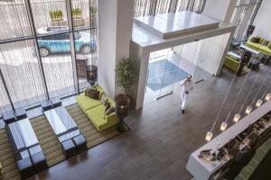 a woman walking through a living room in a building at Centro Shaheen Jeddah by Rotana in Jeddah