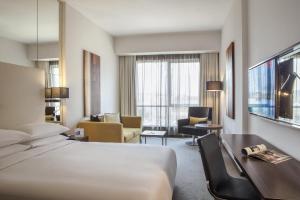 a hotel room with a bed and a living room at Centro Shaheen Jeddah by Rotana in Jeddah