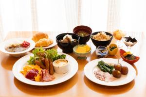 een tafel met borden en kommen eten bij New Grand Hotel in Shinjo