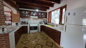 een keuken met een witte koelkast en houten kasten bij Casa Zaragoza in Valle de Bravo
