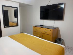 a bedroom with a bed and a flat screen tv at Hotel La Sexta in Tijuana