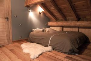a bedroom with a bed and a white dog laying on the floor at Les Alpages d'Auguste in Valloire
