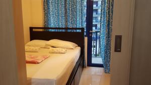 a bedroom with a bed and a window with curtains at FinkSea @ Sea Residences in Manila