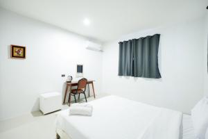 une chambre blanche avec un lit et une table dans l'établissement zNap Yaowarat, à Samphanthawong