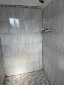 a bathroom with a shower with a tiled floor at Hotel La Sexta in Tijuana +50 photos