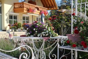 a white bench in front of a house with flowers at Appartement Rehblick in Eisenbach