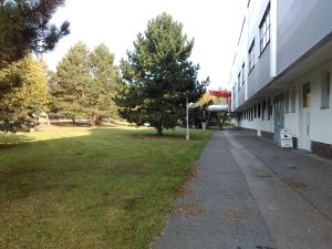 ターボルにあるZimní Stadion Táborの芝生の庭がある建物の横の脇道