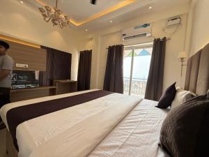 a bedroom with a large bed with a window at Baga Sea shine in Baga