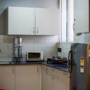 a kitchen with a stove and a toaster oven at Kimaya's Abode in Chandīgarh
