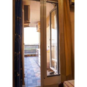 a door leading into a room with a balcony at Kimaya's Abode in Chandīgarh