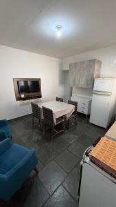 a kitchen with a table and chairs and a refrigerator at Casa com 3 quartos in Itu