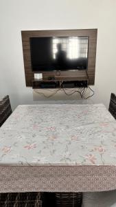 a room with a table with a tv on it at Casa com 3 quartos in Itu