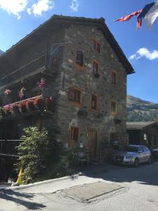 a large stone building with a car parked in front of it at Appartement Beauchocty in Evolène