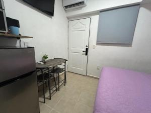 een keuken en eetkamer met een tafel en een deur bij Pequeño Alojamiento in Cancun