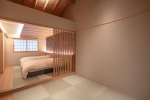ein Schlafzimmer mit einem Bett und einem Fenster in der Unterkunft tango resort ragura kitsu bettei in Kyōtango